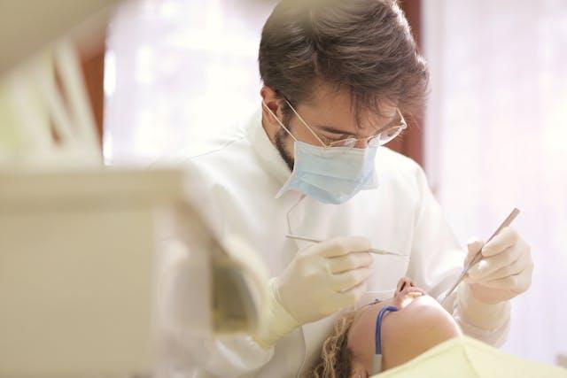 Tandarts controleert het gebit van een patiënt tijdens een behandeling, passend bij het thema tandartsverzekering en orthodontie zonder wachttijd in 2026. De foto illustreert het belang van een goede dekking voor tandheelkundige zorg en orthodontie zonder wachttijd.